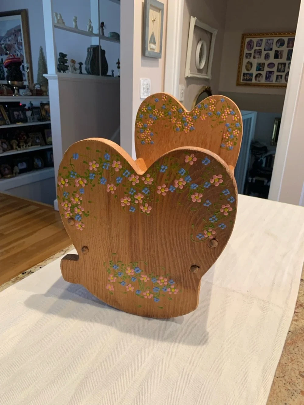 Vintage wooden doll cradle heart-shaped design painted with floral details.